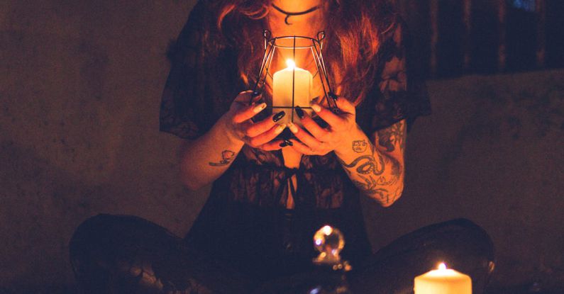 Rituals Power - Spooky witch among candles during ritual