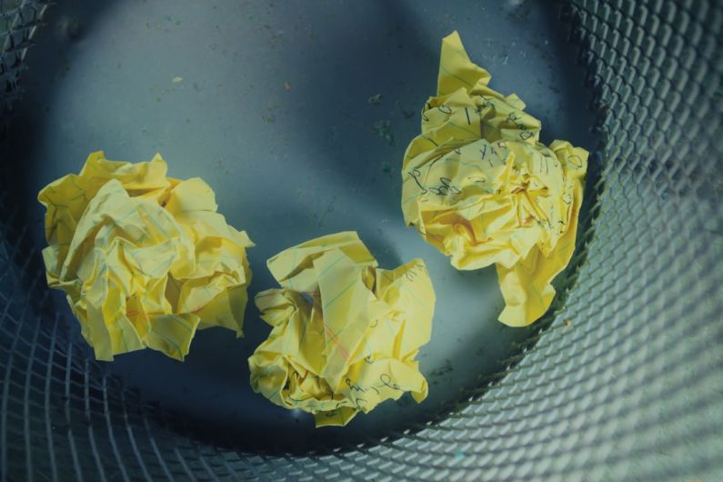 Creative Block - three yellow crumbled papers inside gray trash bin