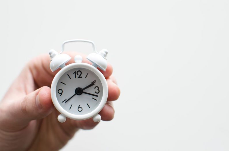 Prioritization Time - person holding white mini bell alarmclock