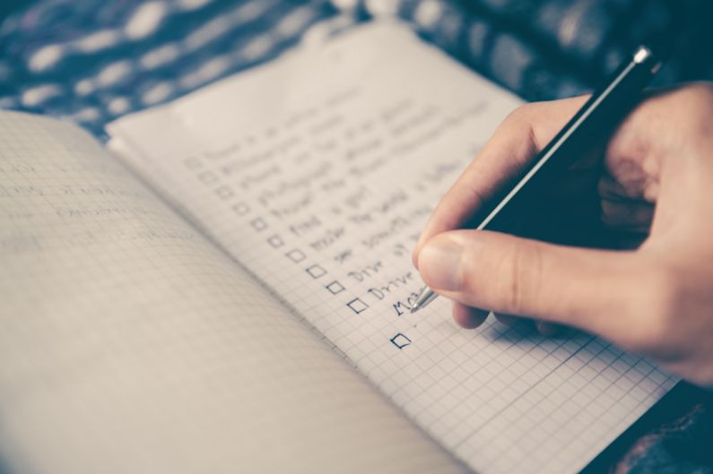 Fitness Productivity - person writing bucket list on book