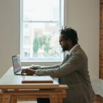 Remote Work - a person sitting at a desk with a laptop and papers