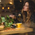 Mindful Eating - woman holding fork in front table