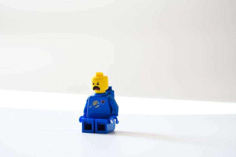 Logic Emotion - blue lego minifig on white surface