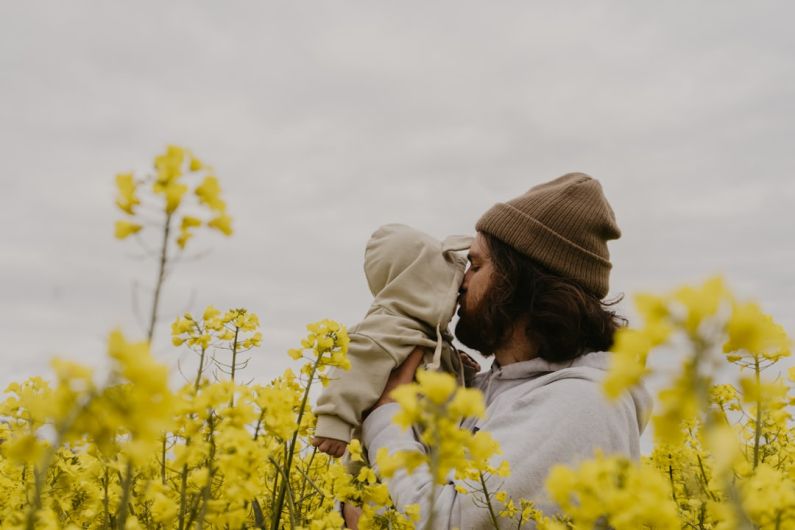Parenting Transition - a man and woman kissing in a field of yellow flowers