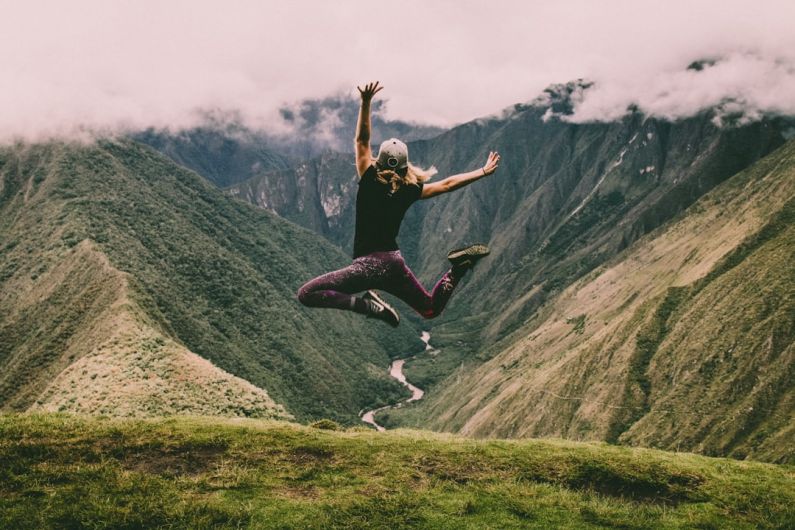 Life Stages - woman jumping on green mountains