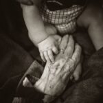 Ageing Fulfilling - an older woman holding a baby's hand