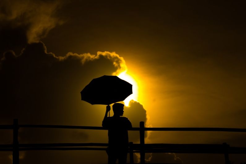 Relationships Mindfulness - a person holding an umbrella in front of the sun