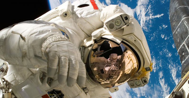 Travel Self-discovery - This picture shows an american astronaut in his space and extravehicular activity suite working outside of a spacecraft. In the background parts of a space shuttle are visible. In the far background of the picture planet earth with it's blue color and white clouds is shown as well as a patch of black space.