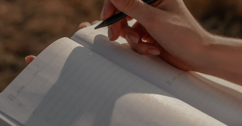 Journaling Impact - Close-up of Woman Writing in a Journal Outdoors